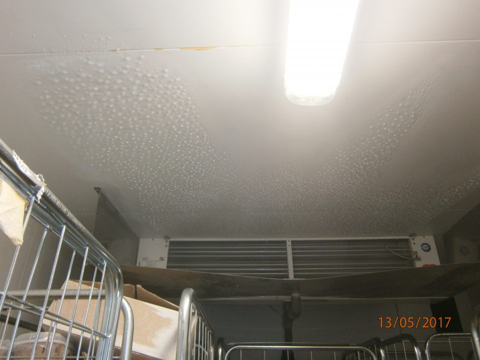 Zamrznutý kondenzát na strope v mraziacom boxe, kvapkajúci na obaly potravín umiestnených pod agregátom.