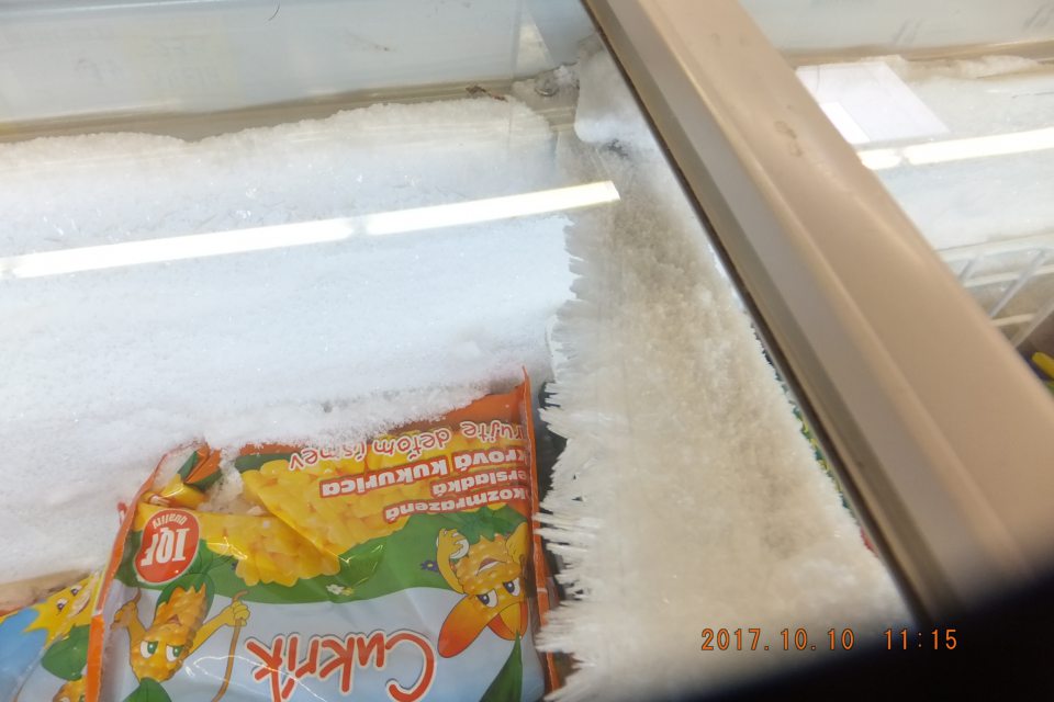 Neúmerná námraza na vnútorných stenách a pod dvierkami mraziaceho boxu určeného na predaj mrazenej zeleniny.