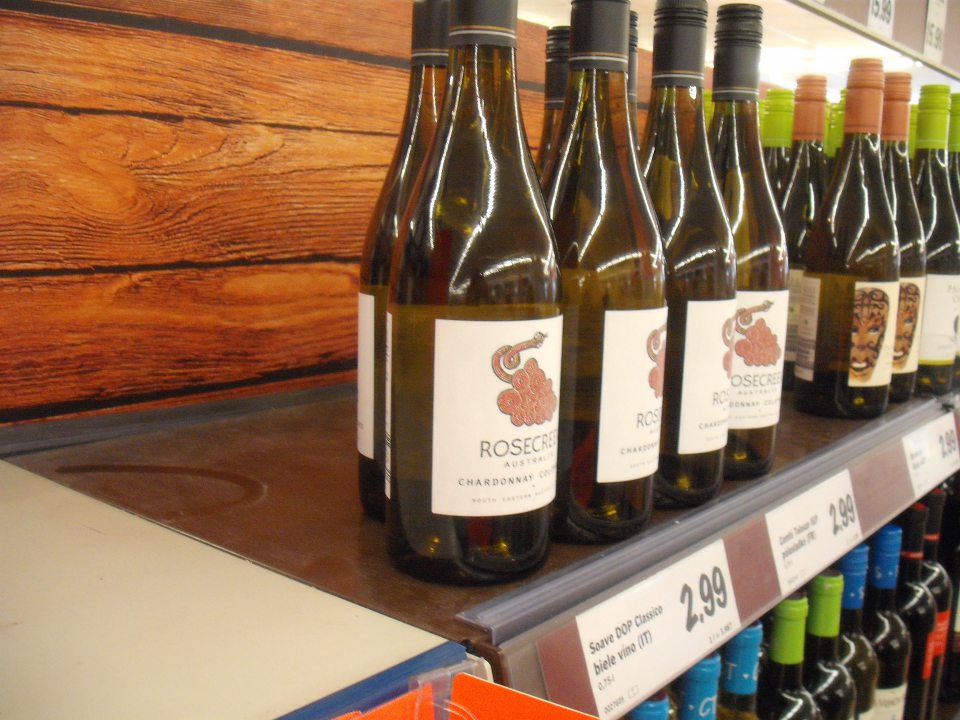 V regáli na víno v predajni potravín nahromadený prach