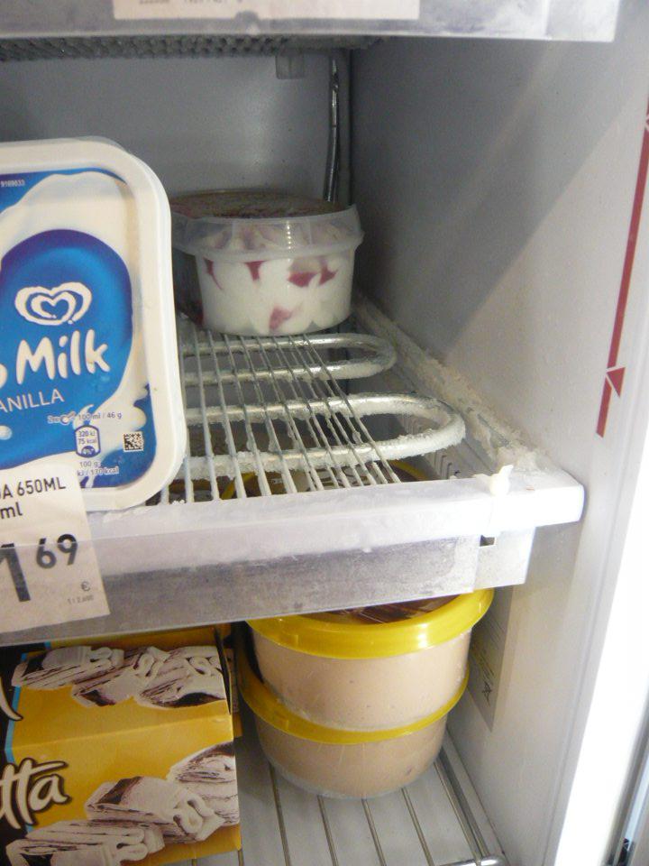 Námraza na mriežkach v mraziarenskom zariadení s mrazenými mliečnymi krémami.