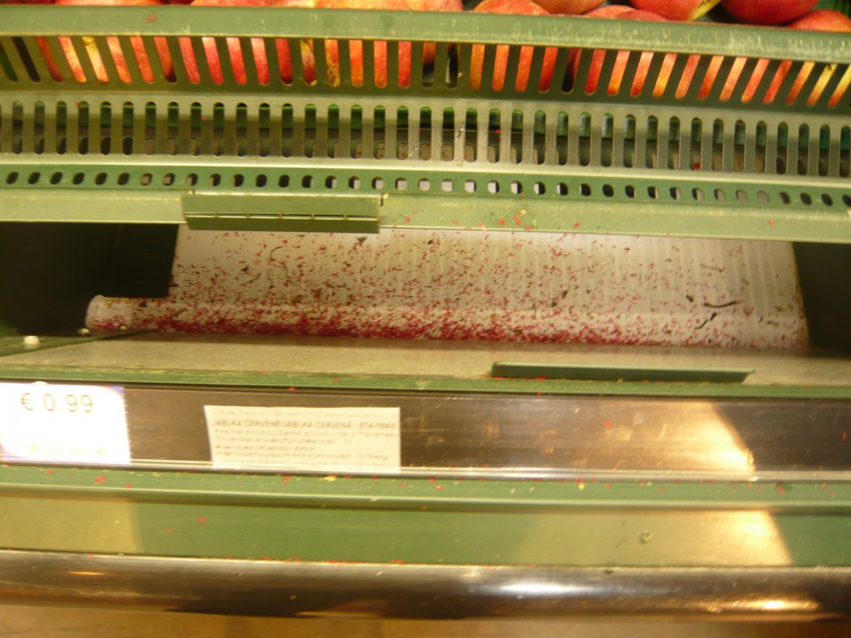 Znečistená chladiarenská vitrína s uchovávanou čerstvou zeleninou a balenými mäsovými výrobkami.