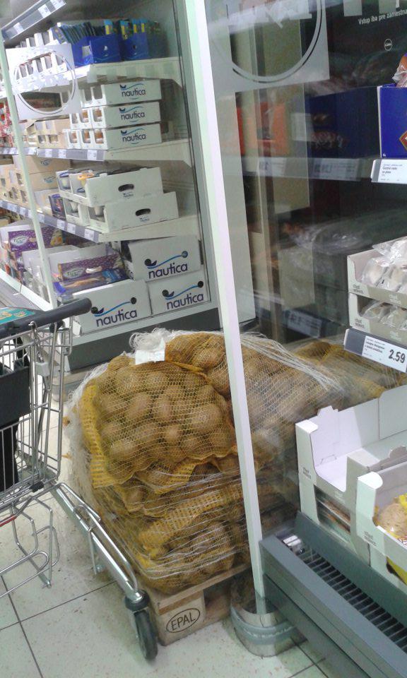 V blízkosti chladiaceho zariadenia na predajnej ploche skladované na palete konzumné neprané zemiaky, na podlahe opadaná zemina.