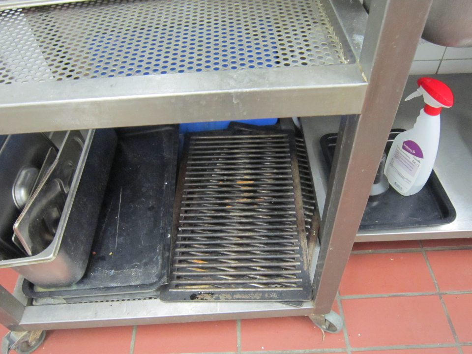 V prípravovni lahôdkárskych výrobkov na stojane slúžiaceho na odkladanie umytých pracovných pomôcok a náradia uložené skorodované  rošty.