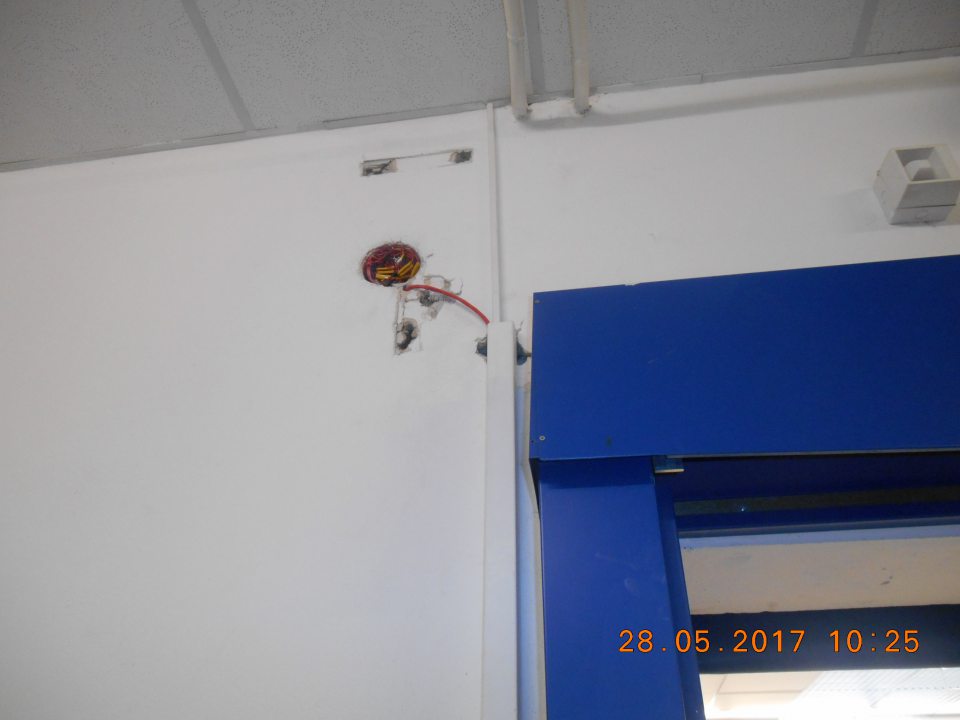 V prevádzke narušená celistvosť steny pri vstupných dverách do skladovacích priestorov.