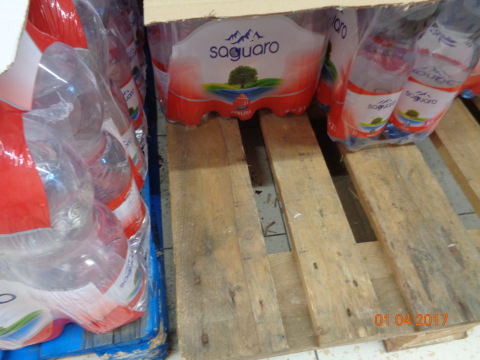 Podlaha na predajnej ploche v okolí drevených paliet a pod nimi znečistená zvyškami potravín, zaschnutými tekutinami, prachom, drobnými nečistotami.