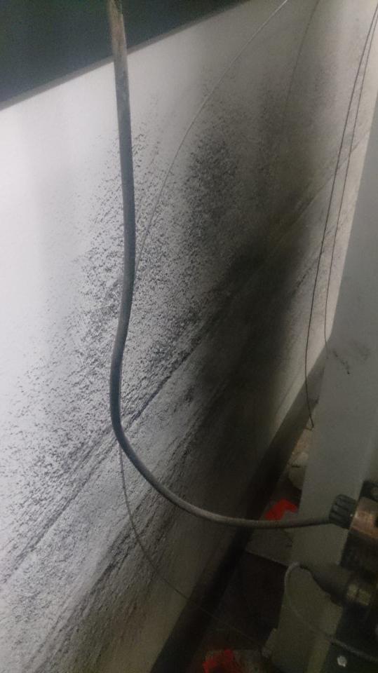 V prevádzke znečistená stena za lisom na kartóny.