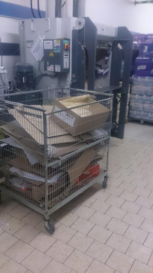 V prevádzke v okolí znečisteného lisu na kartón sa nachádzajú palety s uchovávanými potravinami.