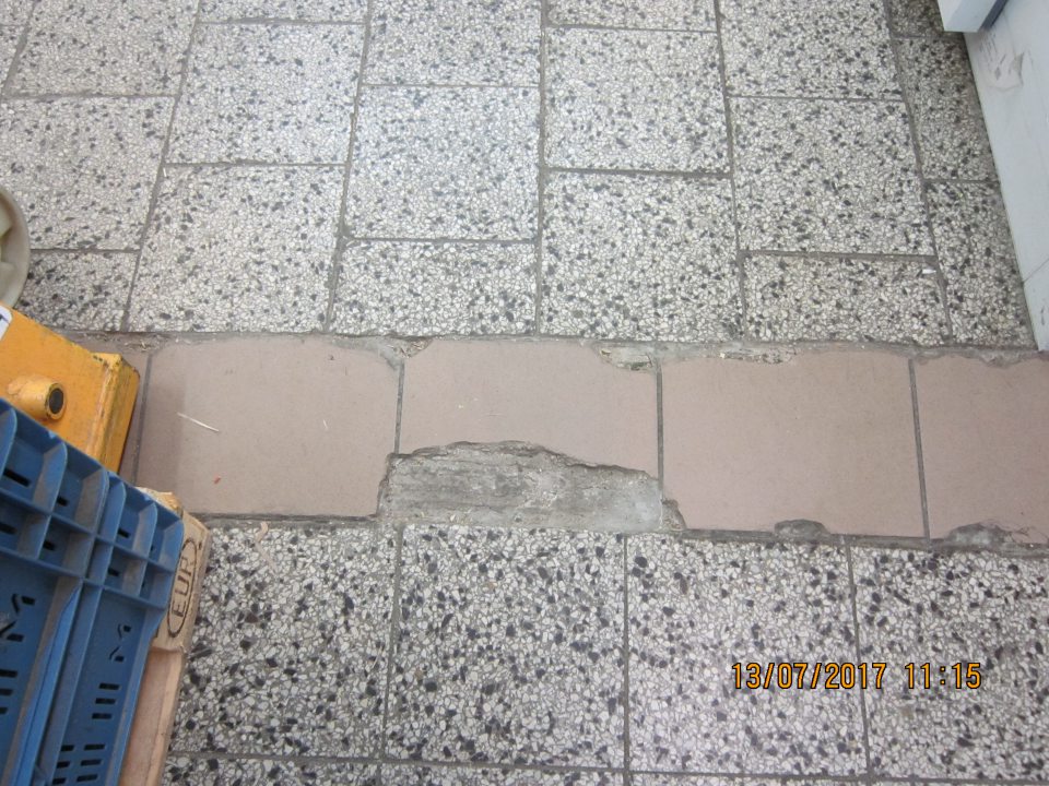 Poškodená dlažba v sklade.