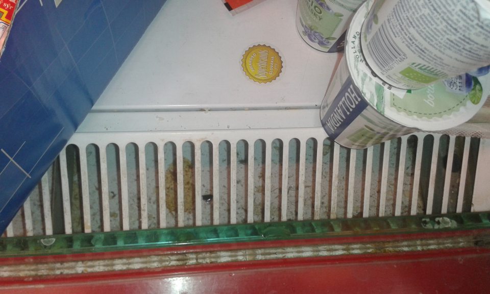 Znečistený priestor pod mriežkou v chladiacom zariadení predajne.