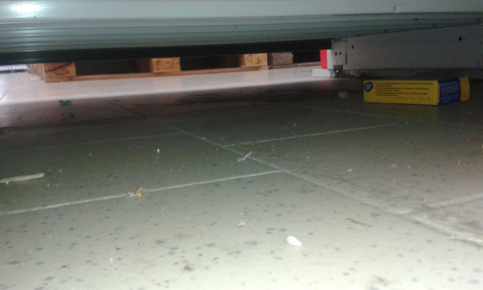 V predajni znečistená podlaha pod regálom. 