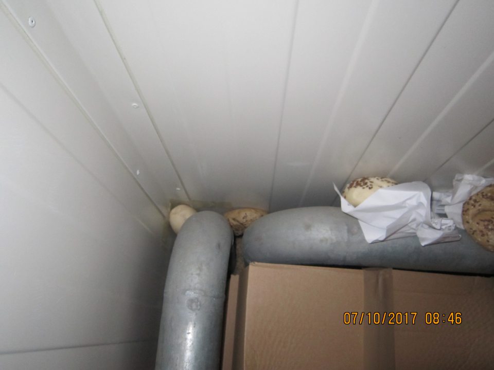 V mraziacom boxe v zázemí prevádzky napadané pekárske polotovary a papiere za kartónmi s tovarom. 