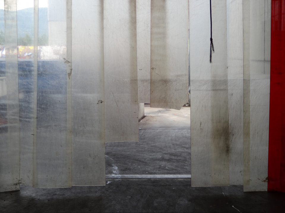 Na rampe odpadového hospodárstva poškodená plastová lamelová dverí. 