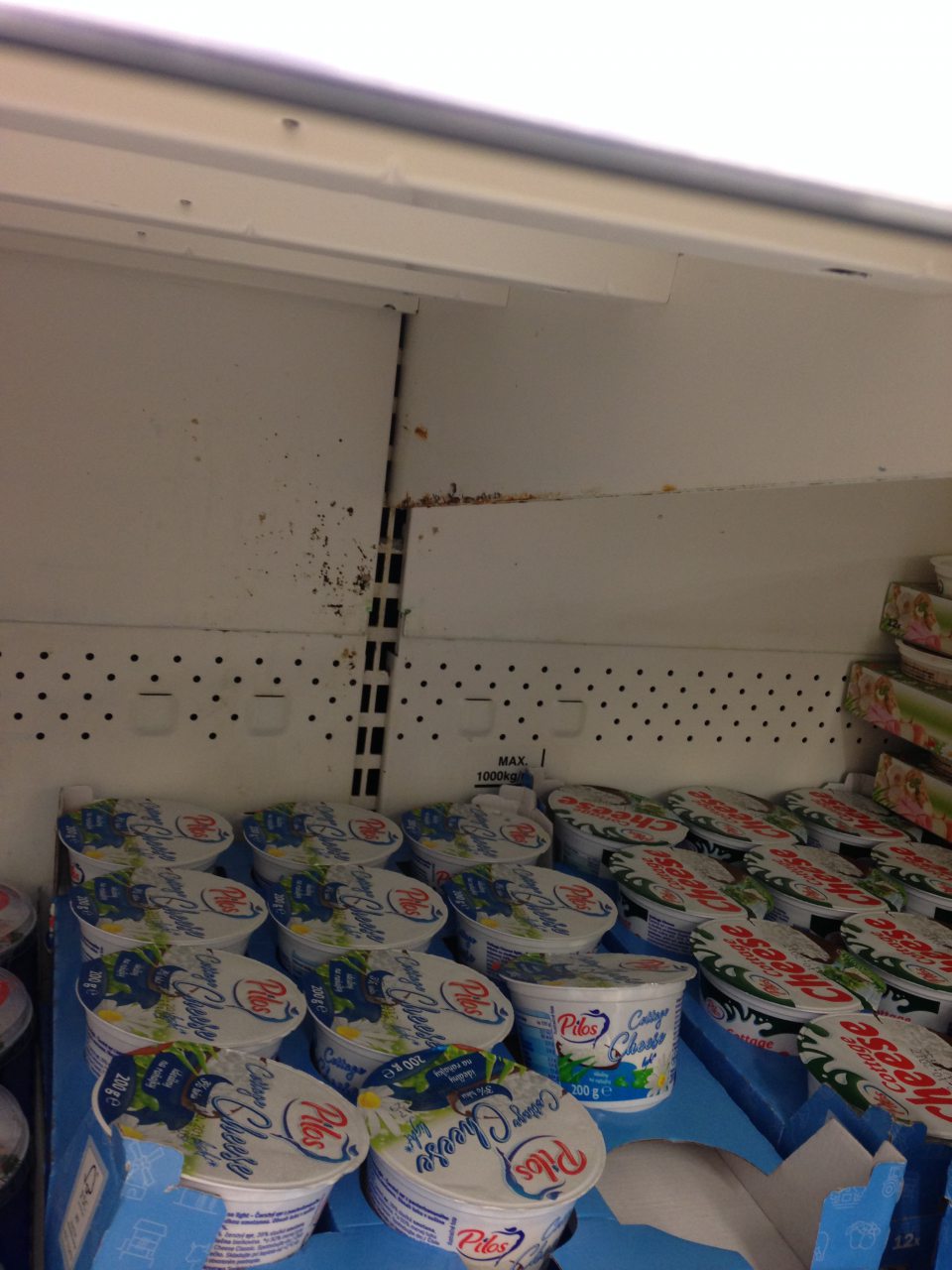 V predajni korózia zadnej časti regálu na syry. 