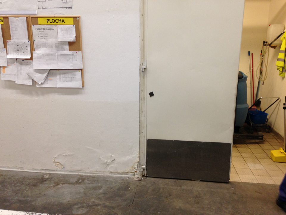 V zázemí prevádzky poškodený a olupujúci sa náter steny.