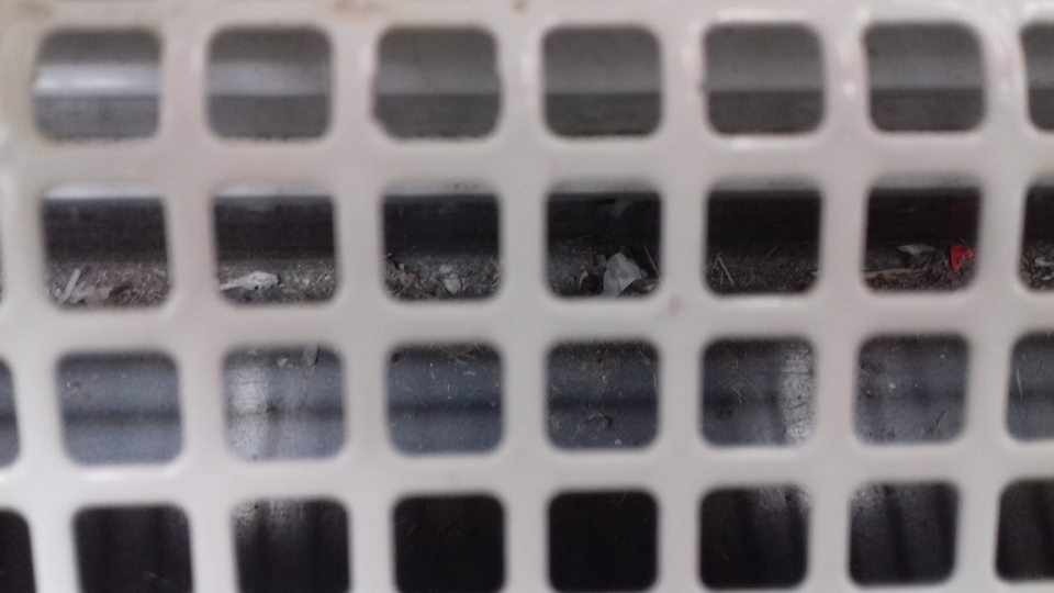 V predajni znečistený priestor pod mriežkou otvorenej chladiacej vitríny.