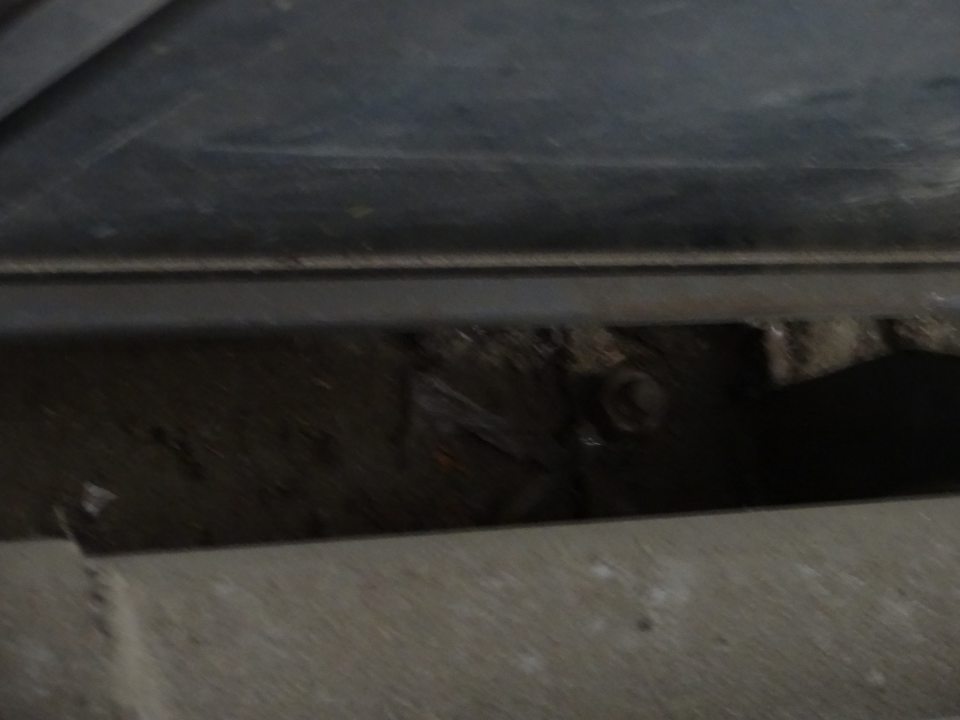 Znečistený priestor za zábranami v sklade potravín pri palete s trvanlivým pečivom.