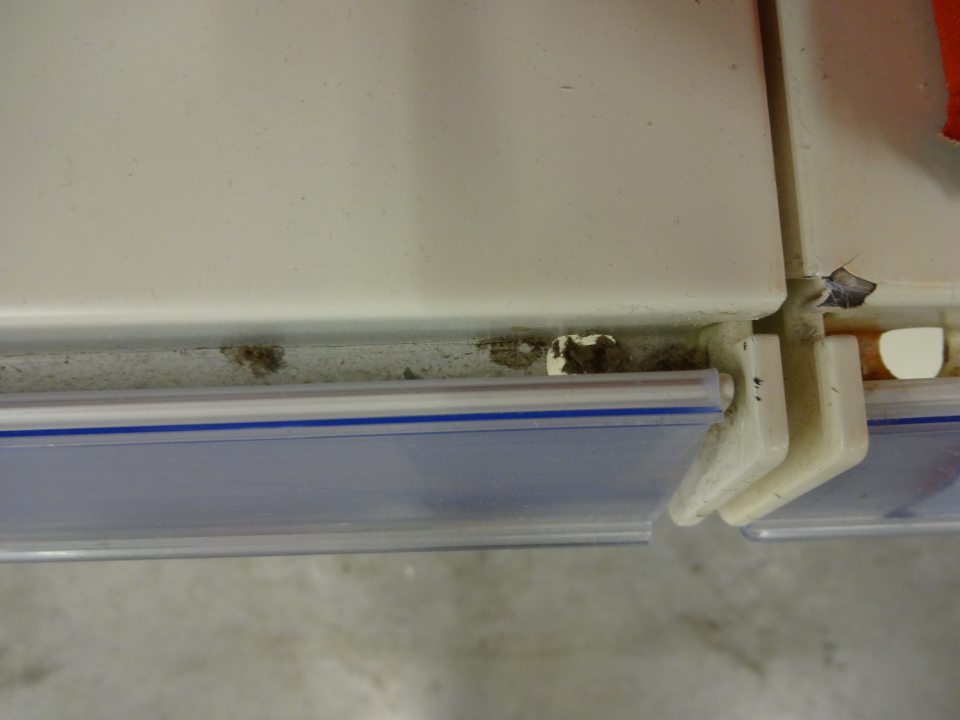 Znečistené regále a žliabky za cenovkovými lištami regálov