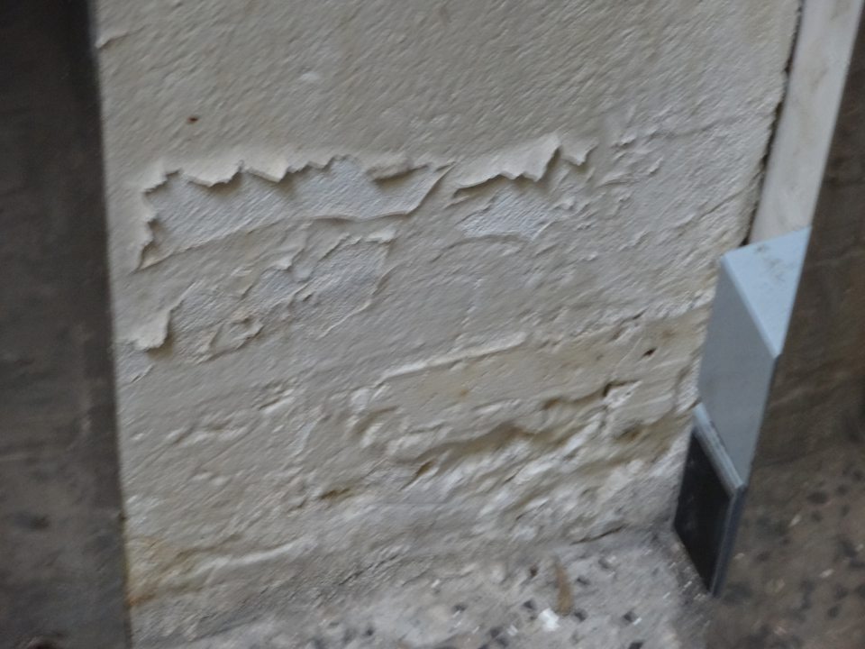 Pred vstupom do chladeného skladu ovocia a zeleniny poškodený, olupujúci sa náter a omietka steny. 