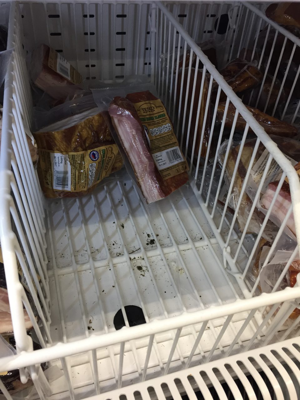 Chladiaca vitrína na predajnej ploche so znečistenou ložnou plochou.