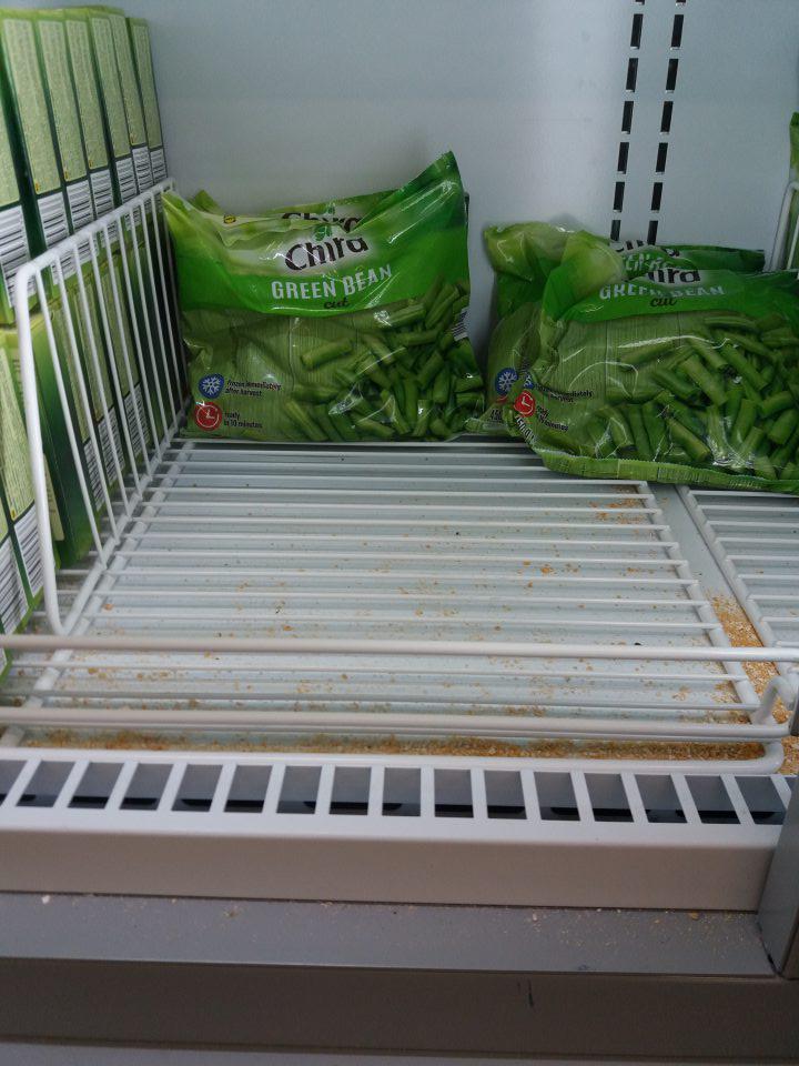 Znečistené dno mraziacej vitríny na predajnej ploche.