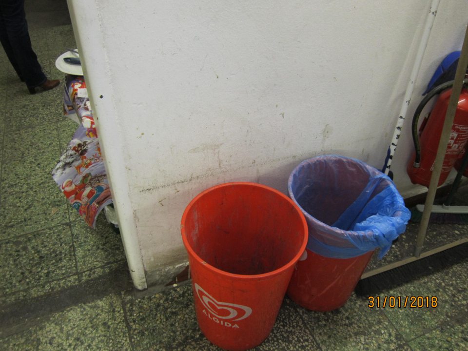 V sklade prevádzky znečistená stena, znečistené odpadkové koše.