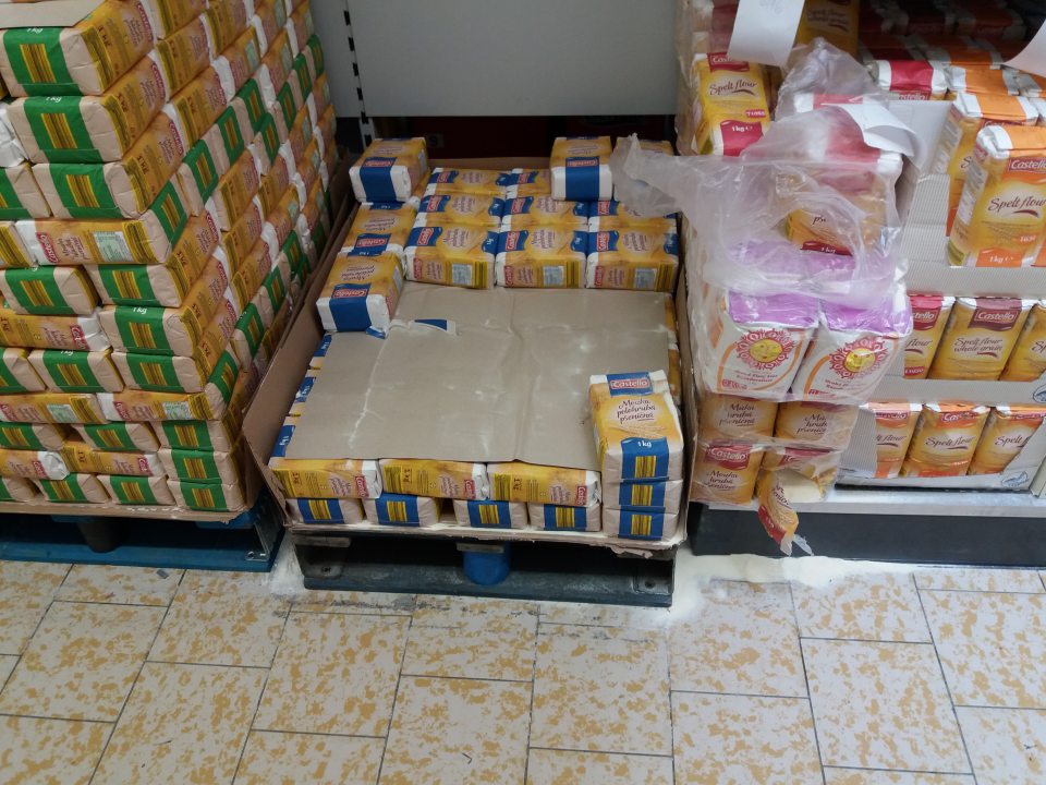 Znečistená podlaha rozsypanou múkou na predajnej ploche.