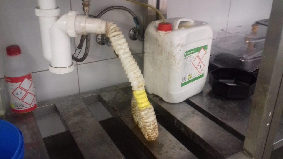 Prípravovňa lahôdok - znečistený priestor pod nerezovým drezom