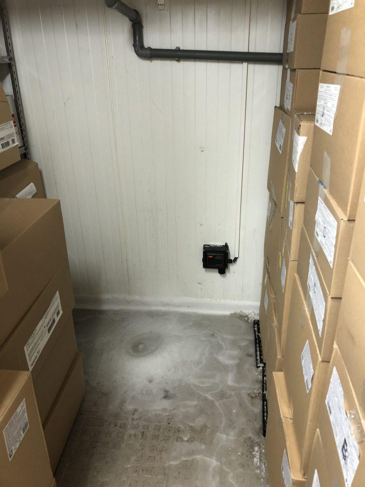 Vrstva ľadu na podlahe pod agregátom v mraziarenskom sklade pečiva.