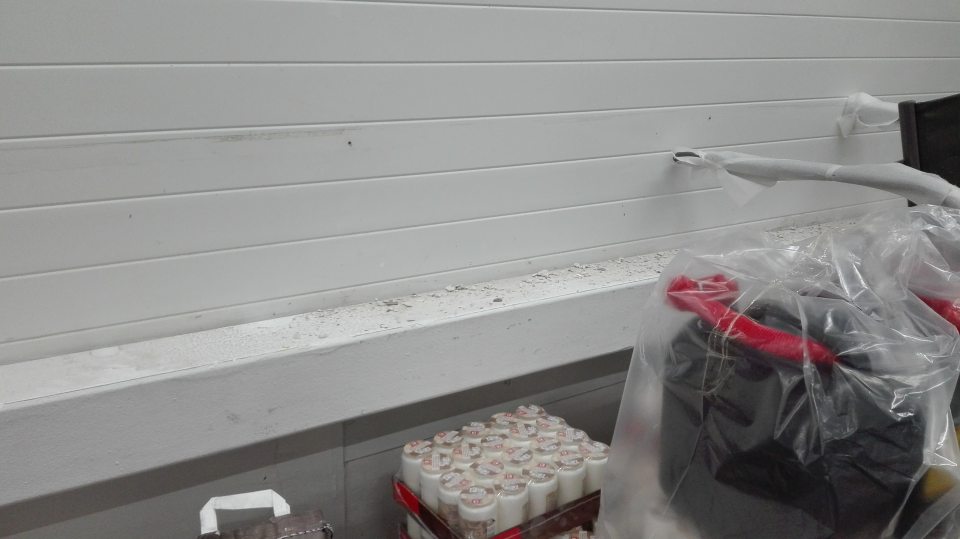 Zaprášený kovový trám s opadanou omietkou v manipulačnej chodbe suchého skladu.