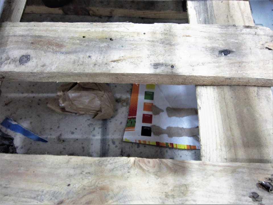 Nadmerne znečistená podlaha pod paletami na sirupy od igelitov, prachu, kartónov, papierov