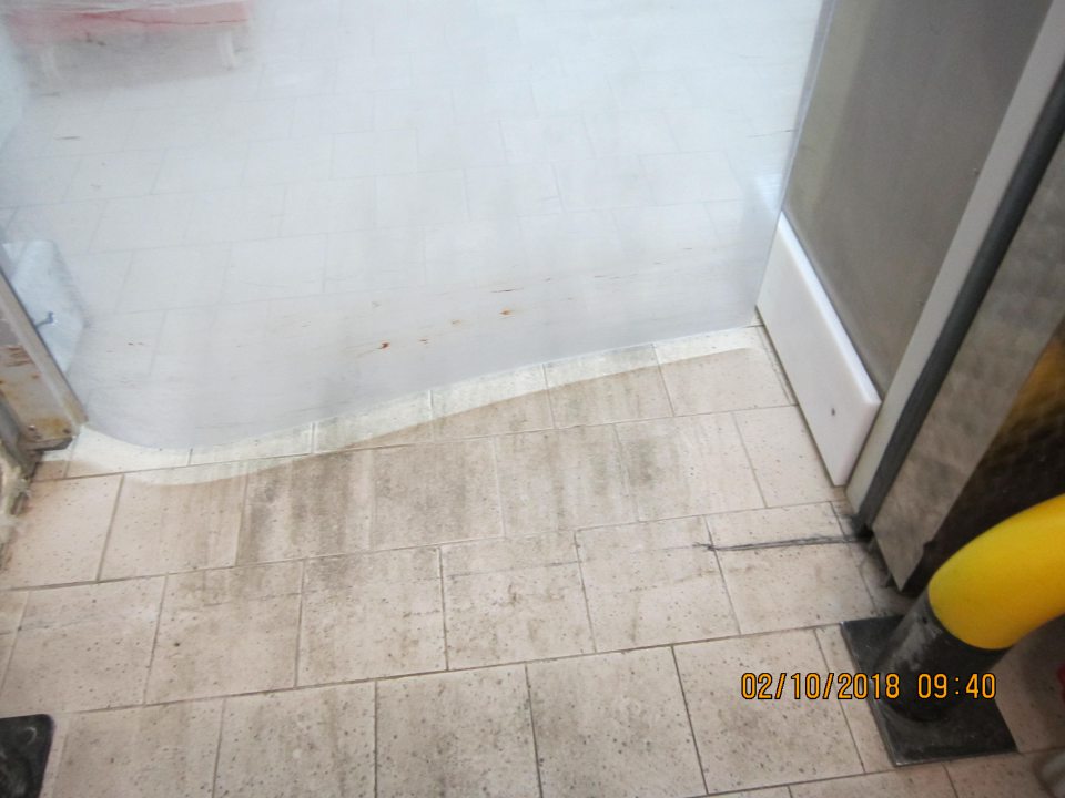 V chladiarni mäsa  znečistená podlaha čiernou špinou.