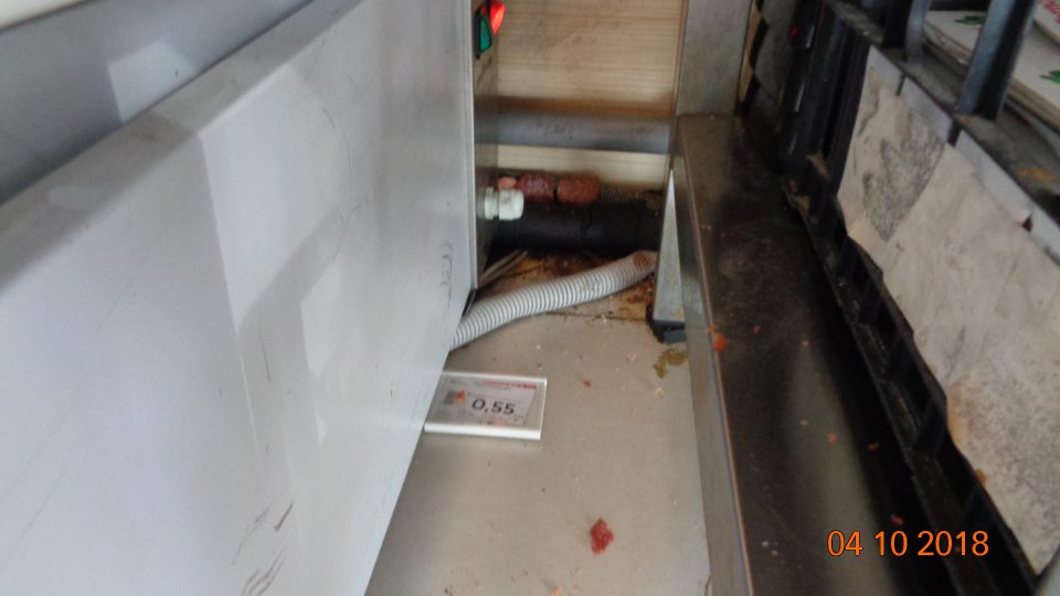 Podlaha v časti pultového predaja znečistená čiernou špinou a zvyškami mäsových výrobkov.