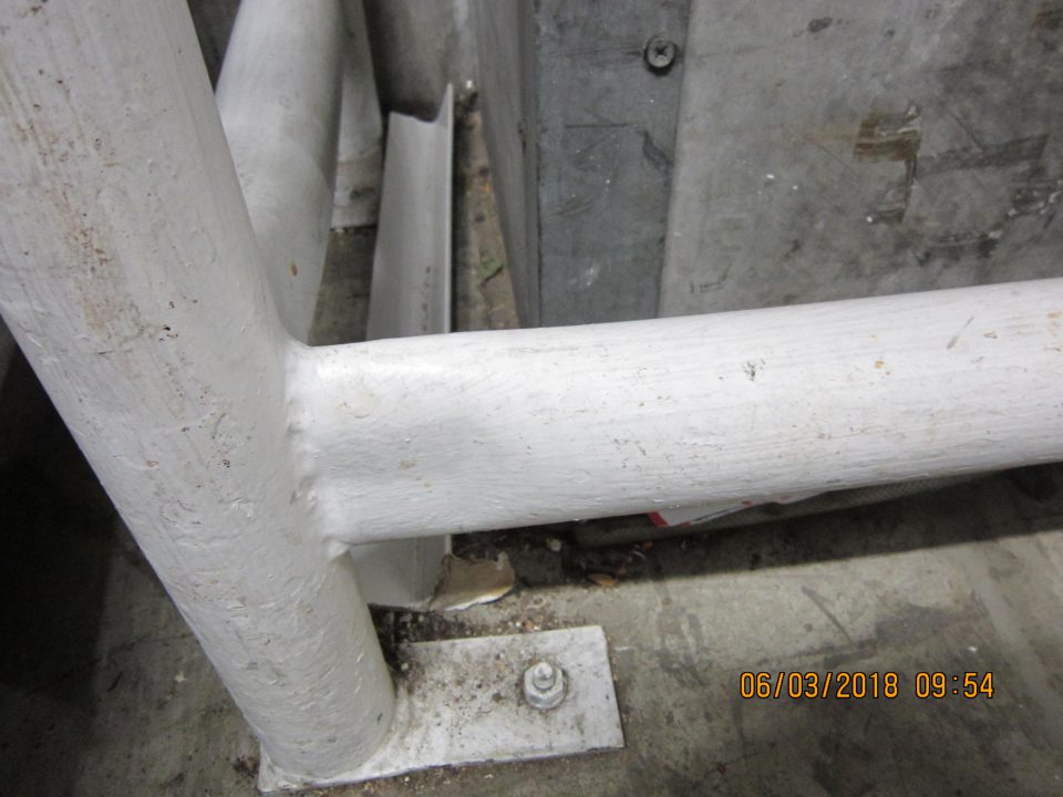 V zázemí pozdĺž celej chodby - znečistená podlaha zbytkami fólii a zhluku prachu pod ochrannými zábranami.