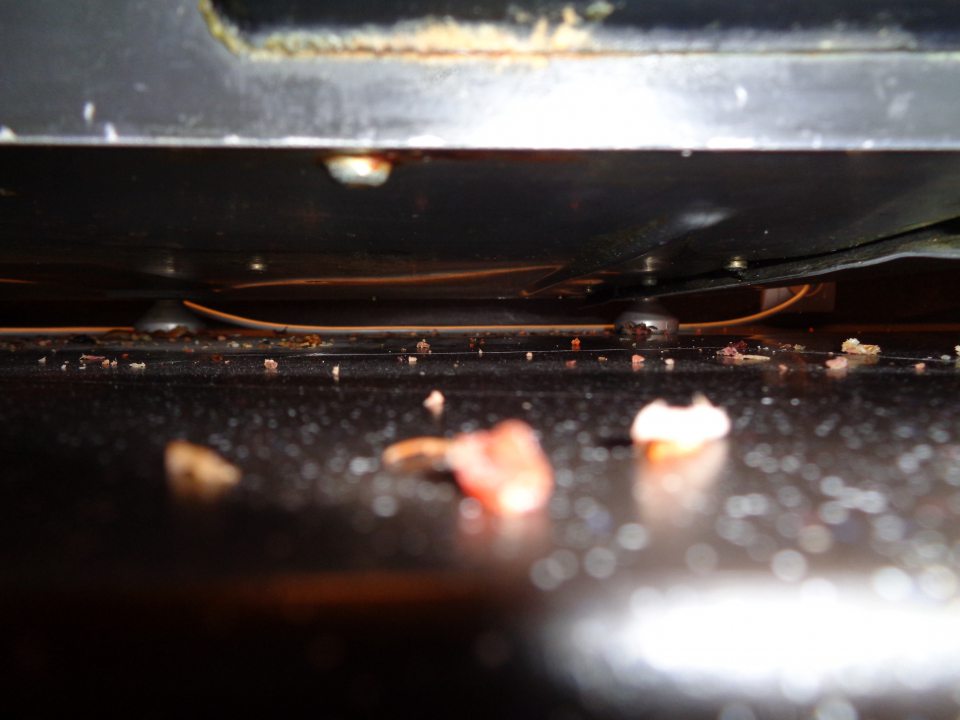 V prevádzke znečistený stôl pod nárezovým strojom.