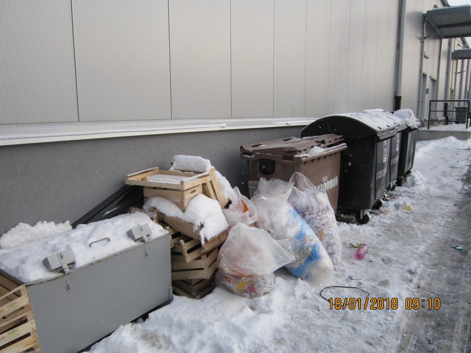 Odpad uložený vo vonkajšom prostredí v plastových vreciach mimo kontajnerov a porozsypaný na zemi.