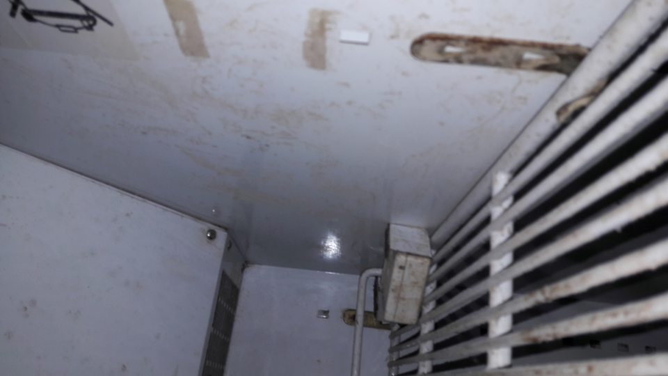 V chladiacej vitríne s výsekovým mäsom v sklade - znečistená úložná plocha v spodnej časti, bočné steny, zadná stena, úložné mriežky a háky.