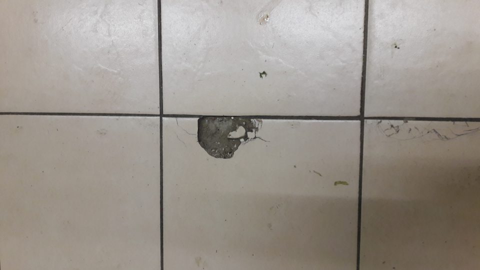 V predajni pred regálom s ovocím a zeleninou poškodený povrch podlahy - výtlky.