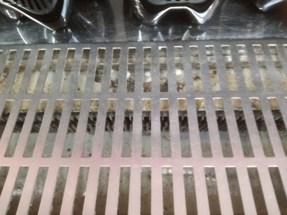Znečistená mriežka v chladiacom zariadení nealko nápojov.