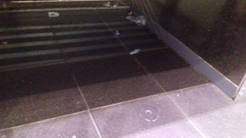 Znečistená podlaha v mäsovom kútiku s uloženým mäsom a mäsovými výrobkami zbytkami po mäsových výrobkoch, papiere.