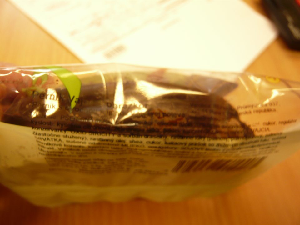  Nečitateľné údaje o zložení výrobkov a ich výrobcovi, uvedených čiernym písmom na tmavom podklade.