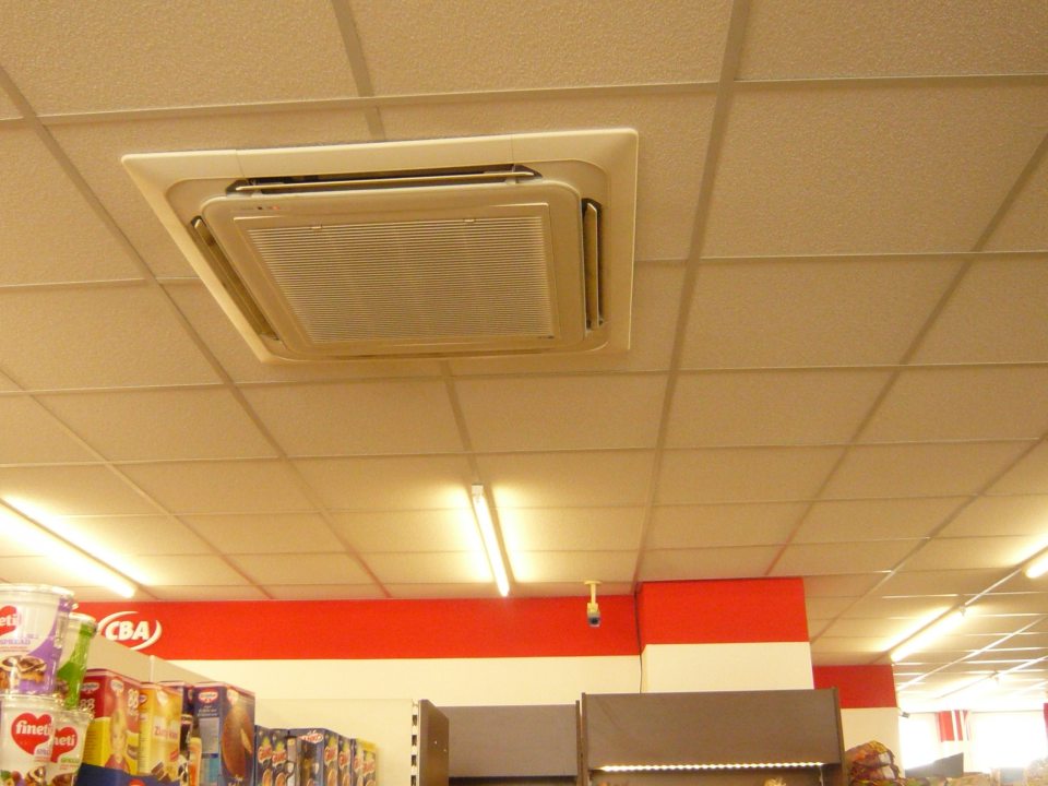 Zistené znečistené stropné klimatizačné jednotky nad regálmi s uchovávaným baleným tovarom na predajnej ploche.