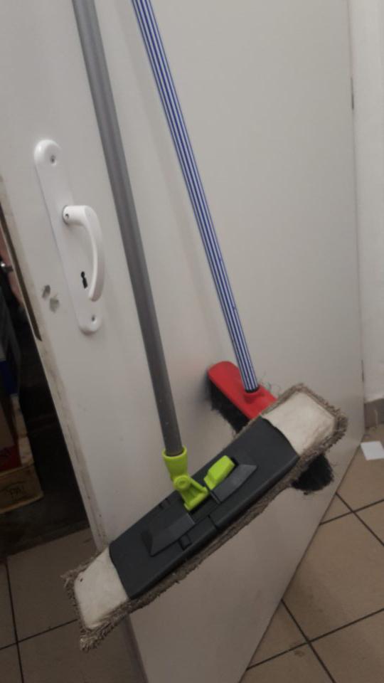 V priestore určenom na skladovanie nebaleného pečiva na dverách z vnútornej strany zavesený znečistený mop, na podlahe znečistená handra.