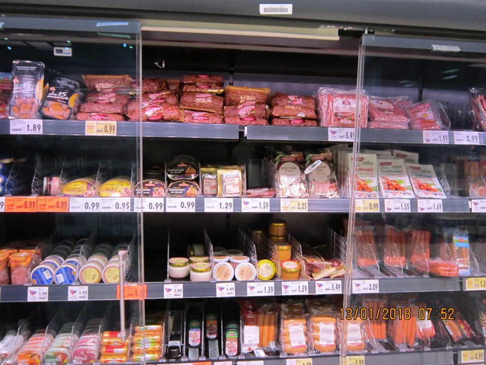 Chýbajúca časť dvojkrídlových dverí uzatvárateľnej chladiacej vitríny na uchovávanie balených mäsových výrobkov na predajnej ploche.