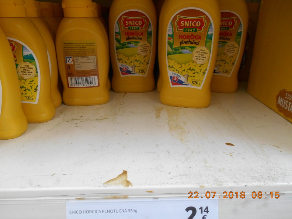 Nánosy prachu a zaschnutá špina na regáli na úseku predaja horčíc na predajnej ploche.