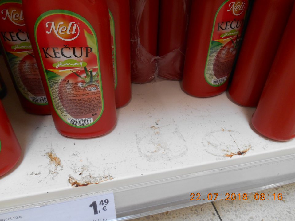 Nánosy prachu a zaschnutá špina na regáli na úseku predaja kečupov na predajnej ploche.
