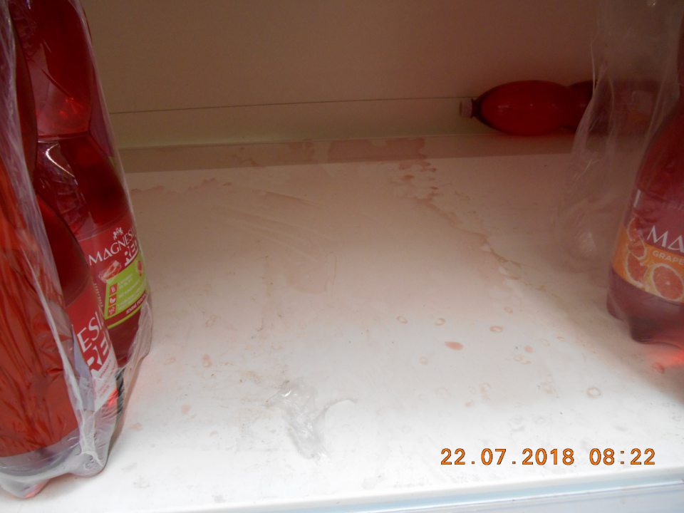 Regál znečistený vyliatym obsahom PET fľaše na úseku predaja ochutených minerálnych vôd na predajnej ploche.