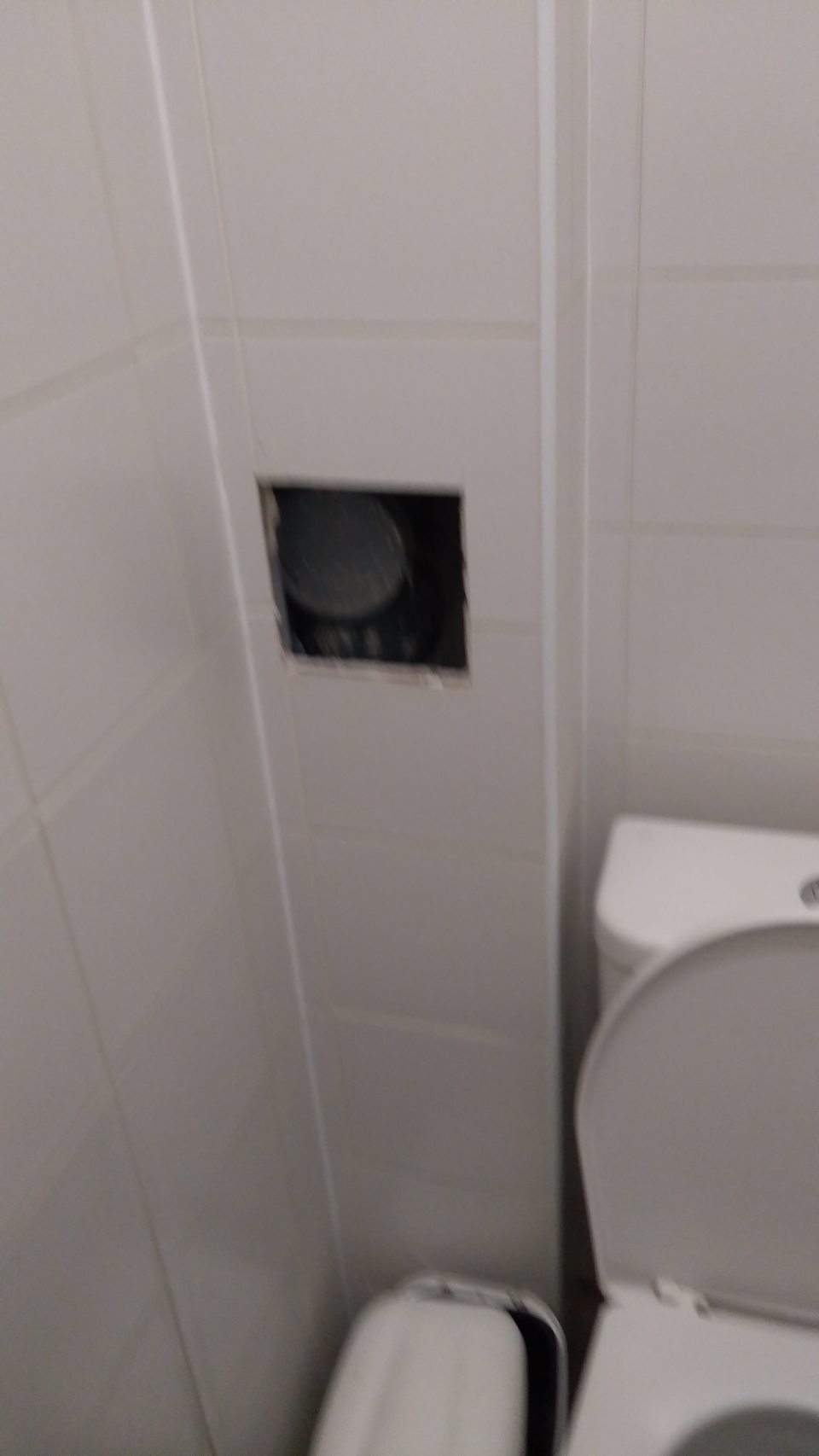 V dámskych toaletách chýba kryt na kontrolnom otvore kanalizačného vedenia na stene.