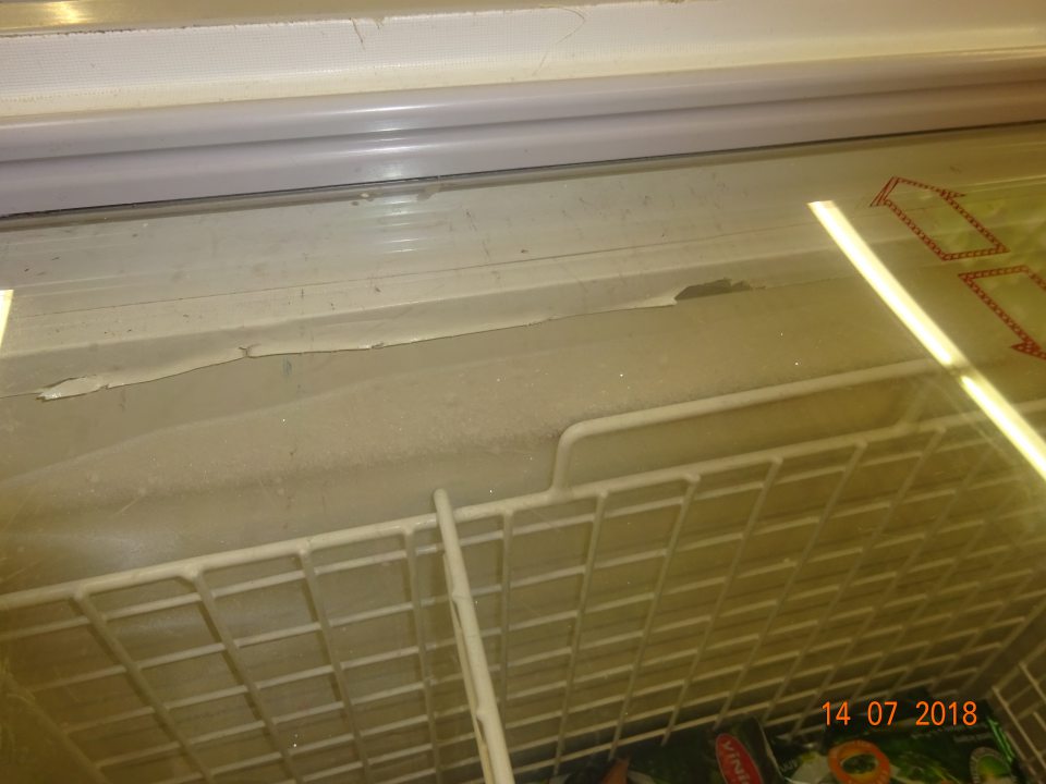 Porušená celistvosť povrchovej úpravy v mraziacom zariadení na predajnej ploche na hlbokozmrazenú zeleninu.