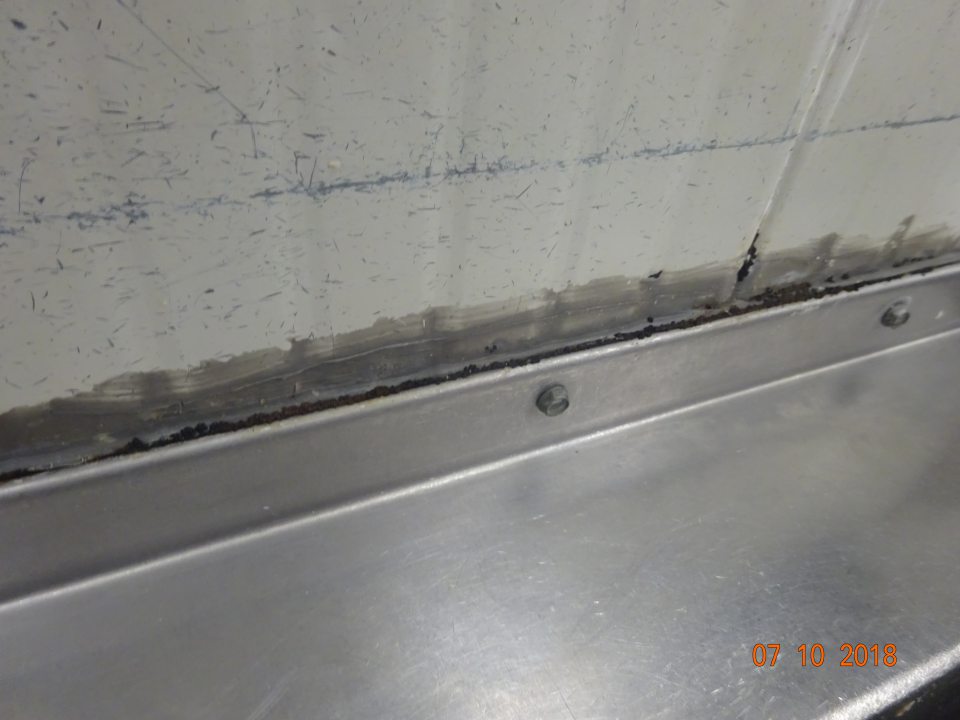 V rozrábke mäsa znečistenie steny za umývadlom v mieste tesnenia čiernymi nečistotami