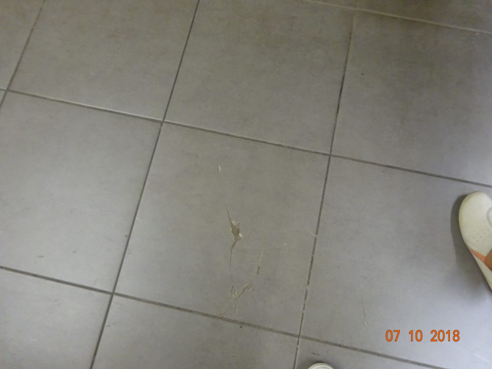 Na predajnej ploche porušená celistvosť dlažby (rozbitá dlaždica) na mieste, kde bolo na paletách uložené pivo a UHT mlieko